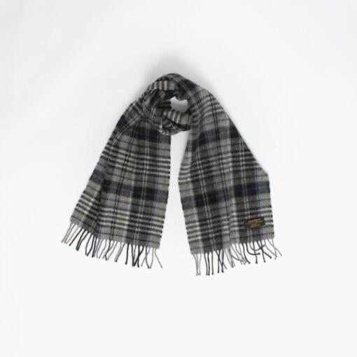 A plaid scarf with fringed ends is laid out against a plain white background