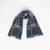 A plaid scarf with fringed ends is laid out against a plain white background.