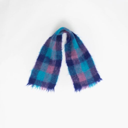 A blue and pink fluffy scarf with fringed ends is laid out against a plain white background.