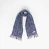 A woven mohair scarf with fringed ends is laid out against a plain white background.