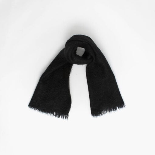 A black fluffy scarf with fringed ends is laid out against a plain white background.