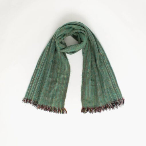 A green alpaca wool scarf with fringed ends is laid out against a plain white background.