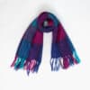 A purple, pink and blue mohair wool scarf with fringed ends is laid out against a plain white background.