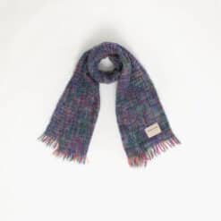 A woven scarf with fringed ends is laid out against a plain white background.